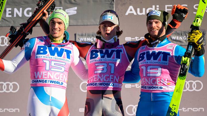 Switzerland's Daniel Yule (L), 2nd place, Norway's Lucas Braathen (C), 1st place, and Italy's Giuliano Razzoli (R), 3rd place, celebrate on the podium after the men's FIS Ski World Cup Slalom in Wengen, Switzerland, on January 16, 2022. (Photo by Fabrice COFFRINI / AFP)
