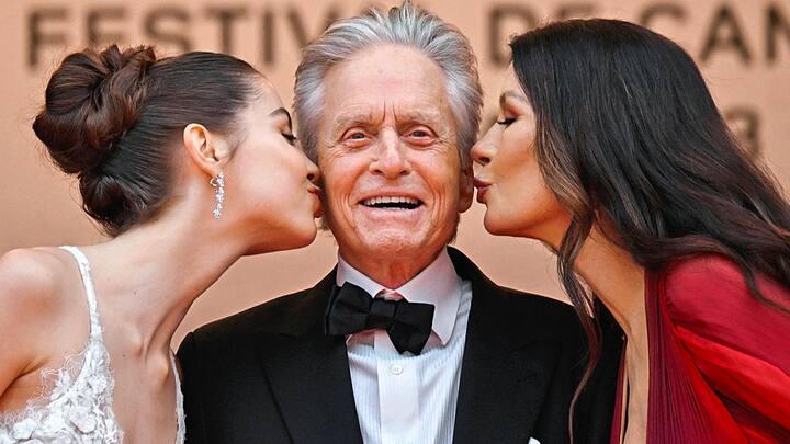 L'actrice britannique Catherine Zeta-Jones et sa fille Carys embrassent l'acteur américain Michael Douglas sur la joue alors qu'ils arrivent pour la cérémonie d'ouverture et la projection du film "Jeanne du Barry" lors de la 76e édition du Festival de Cannes à Cannes, dans le sud de la France, le 16 mai 2023.