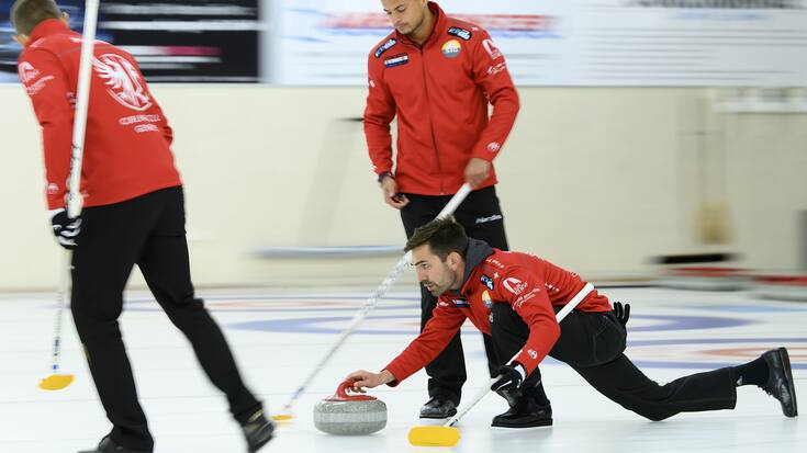 Skip Peter de Cruz (Genf), unten, wirft den Stein mit seinem Teamkollegen Valentin Tanner, oben, und Sven Michel, links, bei den Curling Olympia-Trials um die Qualifikation fuer die Olympischen Spiele 2022 in Peking zwischen Team Schwaller (Bern Zaehringer) und Team de Cruz (Genf), am Freitag, 24. September 2021, in der Curlinghalle in Biel. (KEYSTONE/Anthony Anex)