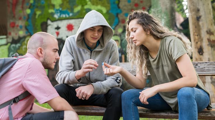 des amis fument un joint dans un parc