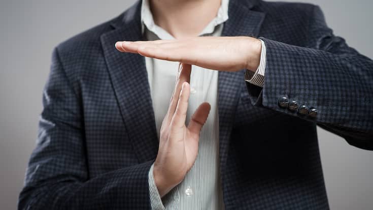 young businessman showing time out sign with hands against
