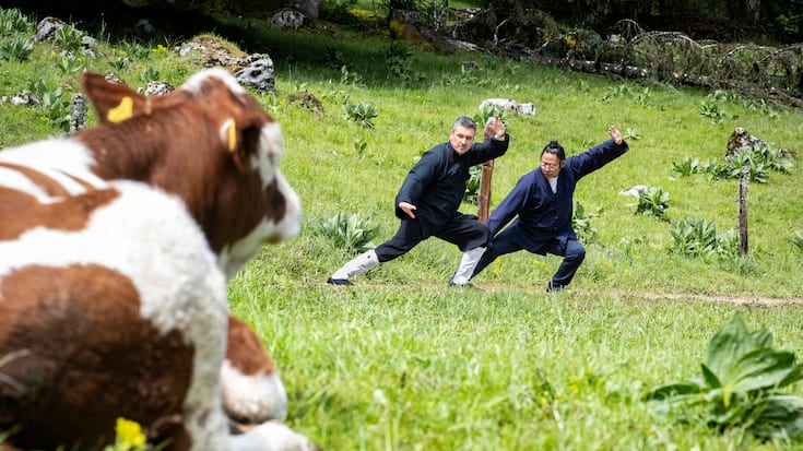 Le prêtre Fabrice Jordan et son maître, Liu Yuan Tong, en pleine démonstration de qi gong dans un pâturage du Jura vaudois