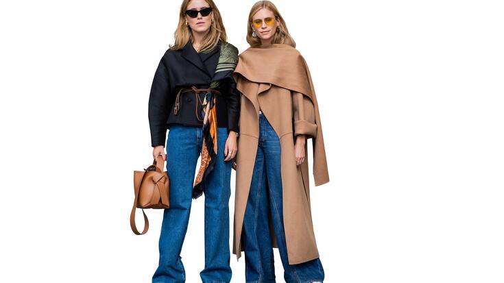 Annabel Rosendahl portant un sac marron, une écharpe Loewe, un jean en denim et Tine Andrea portant un manteau marron, un jean en denim vus lors du Stockholm Runway SS19 le 29 août 2018 à Stockholm, Suède. 