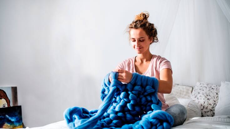 Frau strickt mit den Armen
