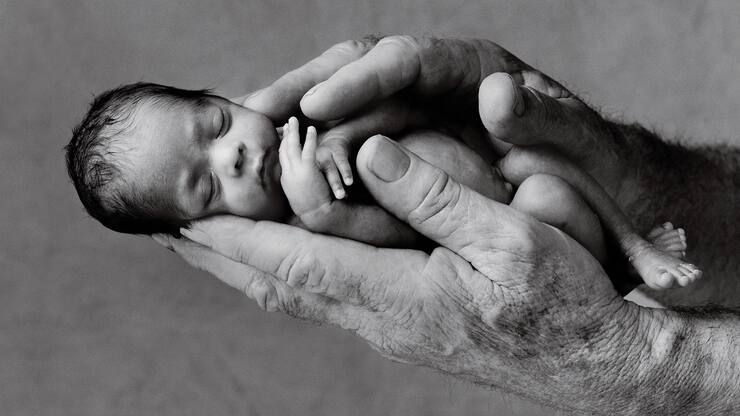 Un nouveau né tient dans deux mains.