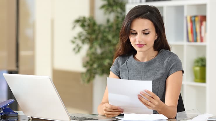 Portrait of a businesswoman working at office reading a letter in a desktop 