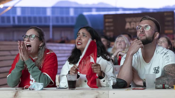Swiss soccer fans react during the live broadcast of the UEFA EURO 2020 soccer match between France and Switzerland at the public viewing zone Wood Ball Arena in Bulle, Switzerland, Monday, 28 June 2021. (KEYSTONE/Cyril Zingaro)