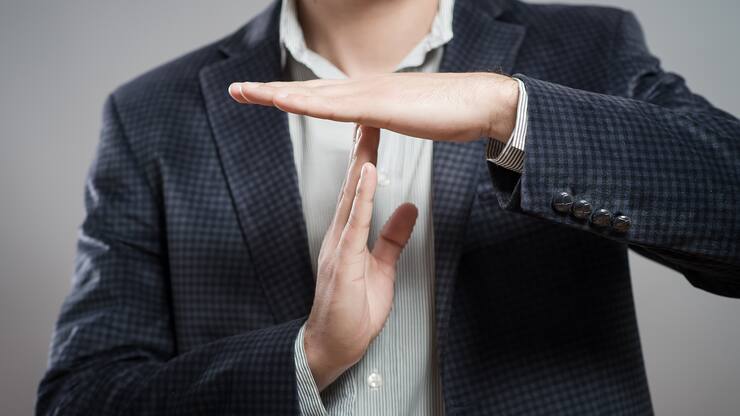young businessman showing time out sign with hands against