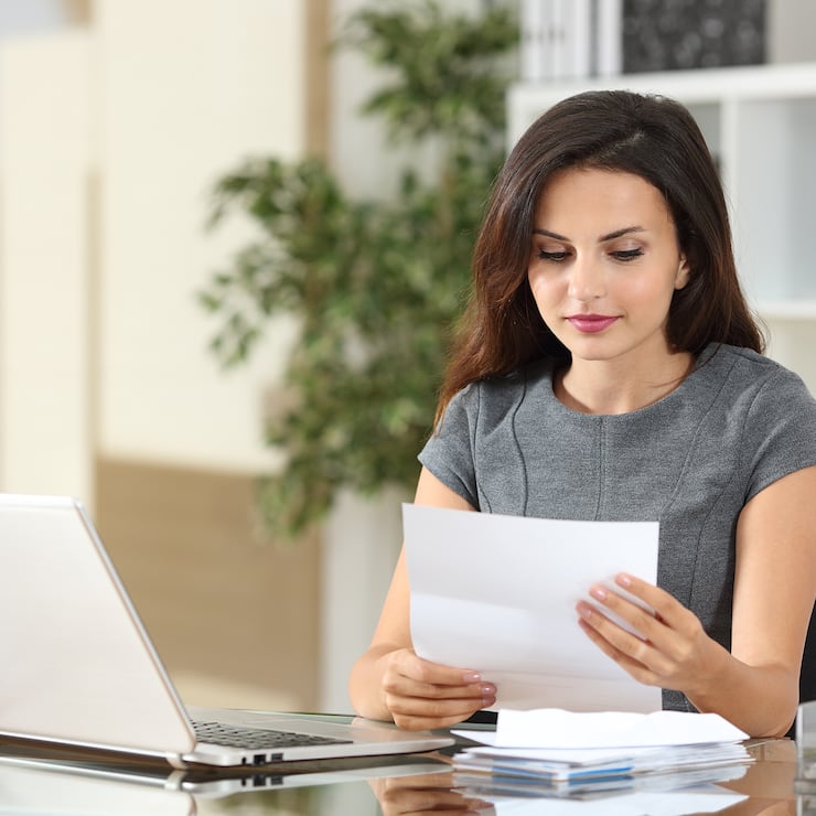 Portrait of a businesswoman working at office reading a letter in a desktop 