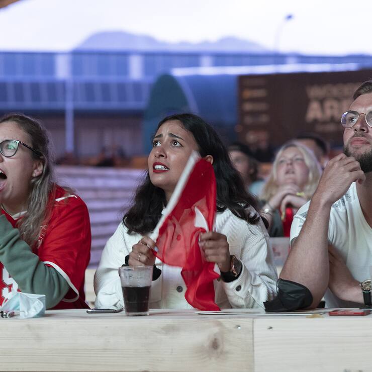 Swiss soccer fans react during the live broadcast of the UEFA EURO 2020 soccer match between France and Switzerland at the public viewing zone Wood Ball Arena in Bulle, Switzerland, Monday, 28 June 2021. (KEYSTONE/Cyril Zingaro)