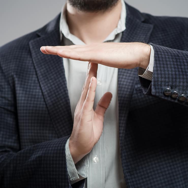 young businessman showing time out sign with hands against