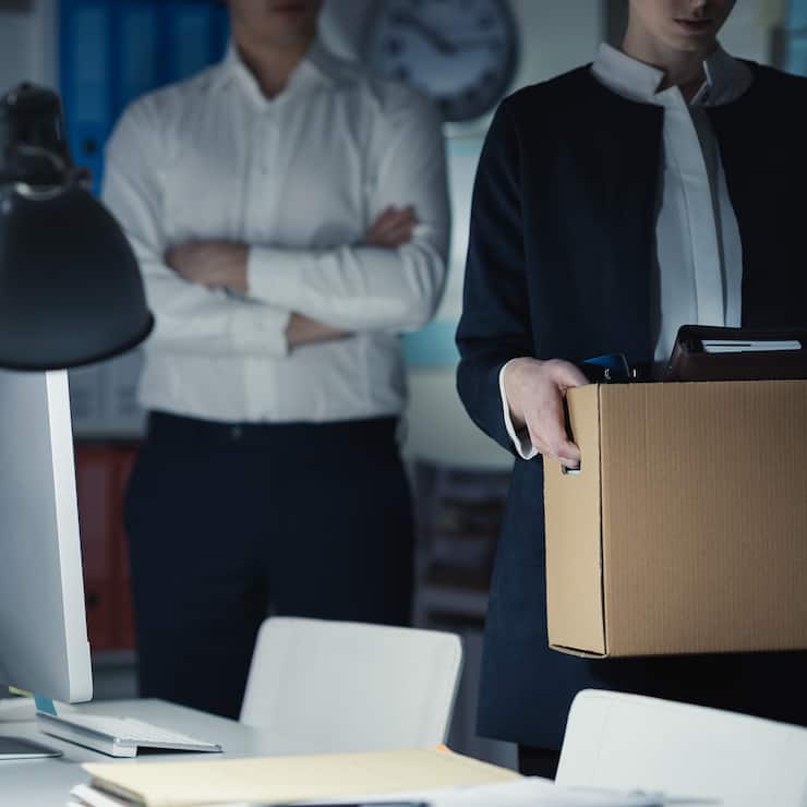 Licenciement immédiat: Une employée quitte son bureau sous le regard sévère de son chef