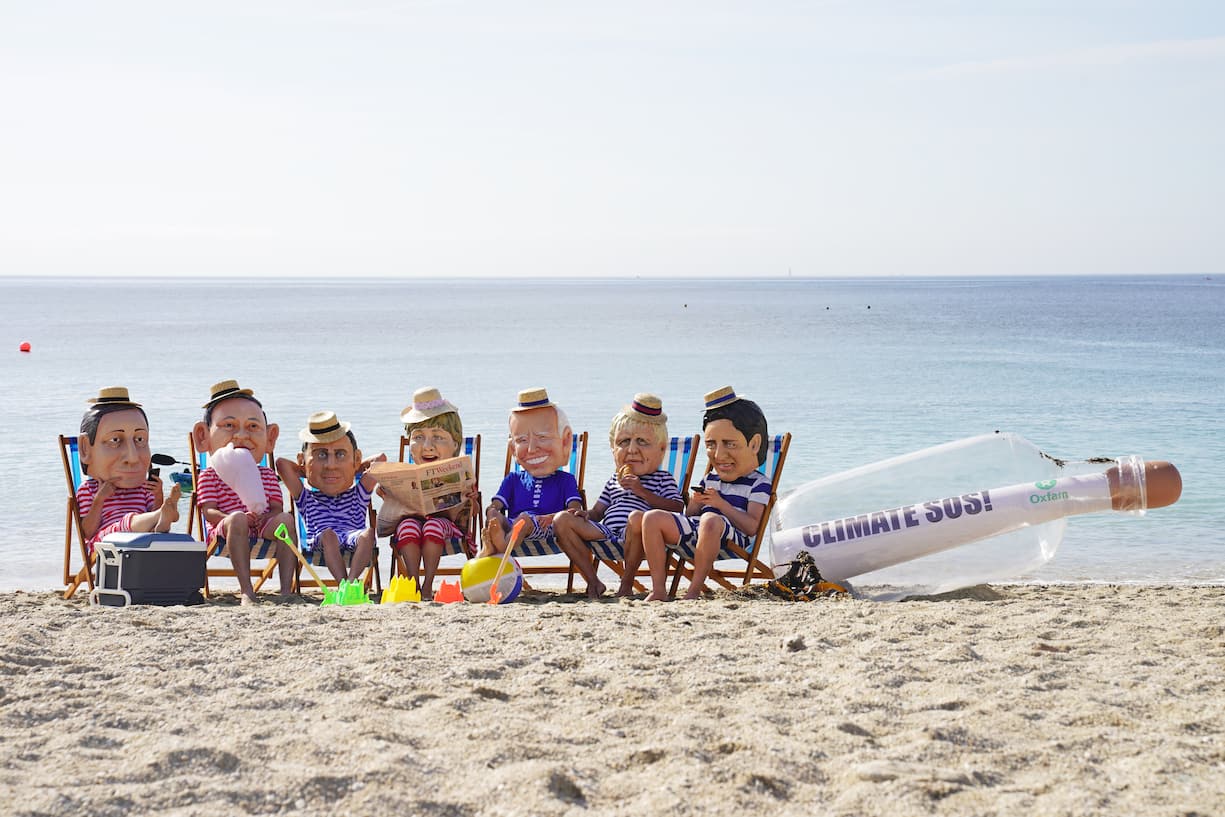 Oxfam campaigners pose as G7 leaders on Swanpool Beach near Falmouth, Cornwall. (FOTO: DUKAS/PA PHOTOS)