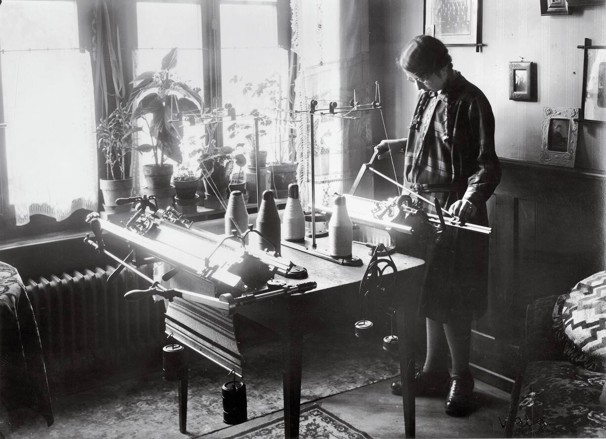 Femme manipulant une machine à tricoter
