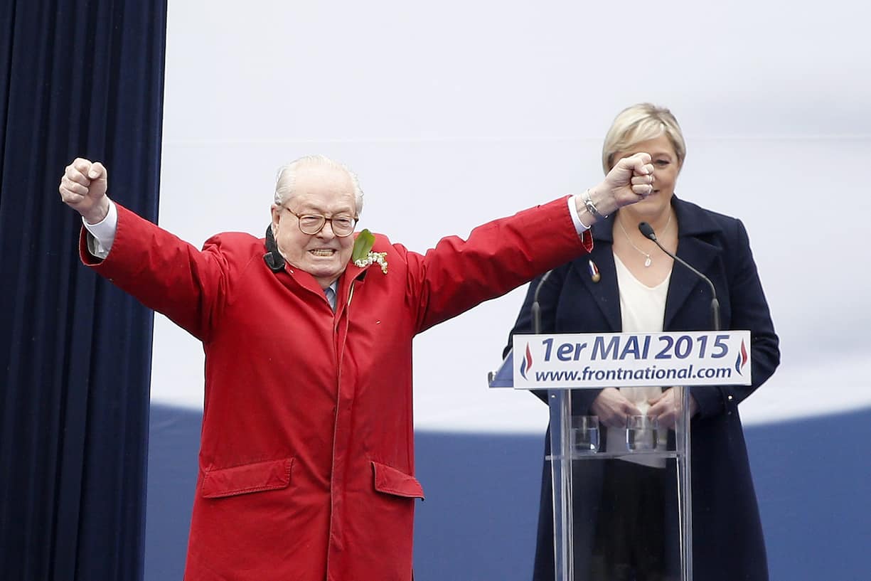 epa04728141 Former President of the Front National (FN) Jean-Marie Le Pen (L) gestures toward the audience as his daughter, the actual president, Marine Le Pen (R) looks on during the traditional May Day rally of the Front National (FN) party by the Opera Garnier in Paris, France, 01 May 2015. EPA/YOAN VALAT