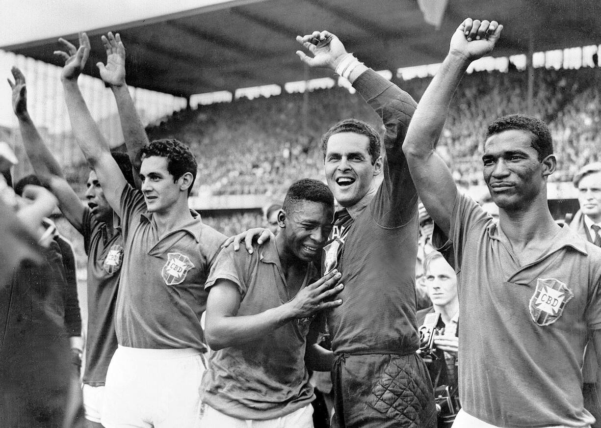 La star brésilienne Pelé, 17 ans, au centre, pleure sur l'épaule du gardien Gylmar Dos Santos Neves après la victoire 5-2 du Brésil sur la Suède en finale de la Coupe du monde de football à Stockholm, le 29 juin 1958. 