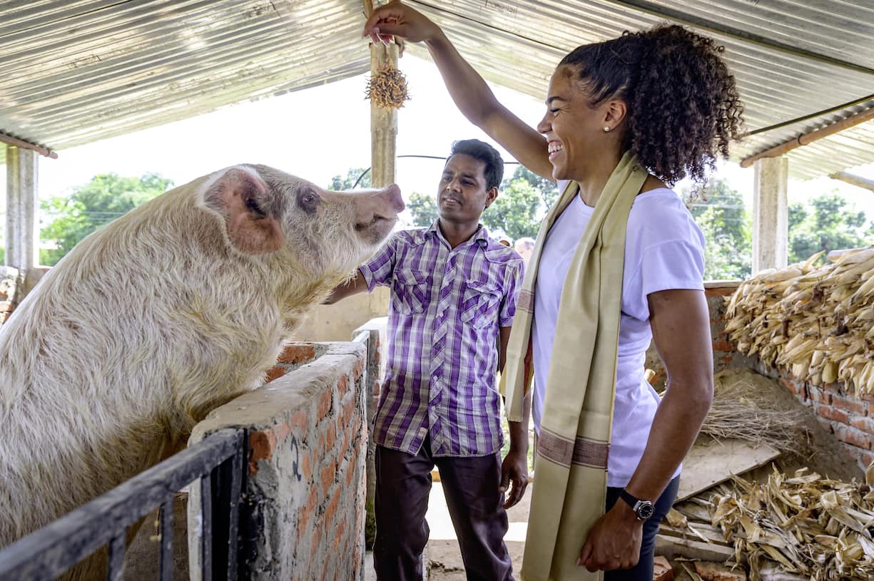 Mujinga Kambundji à Dhanauri, aidant un paysan à nourrir ses porcs