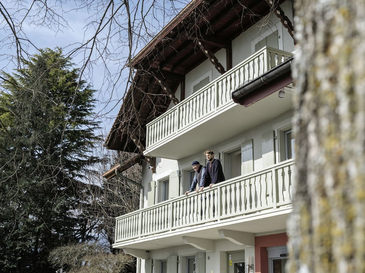 Jean-Claude et Pierre Biver au balcon du premier étage d'une ferme.