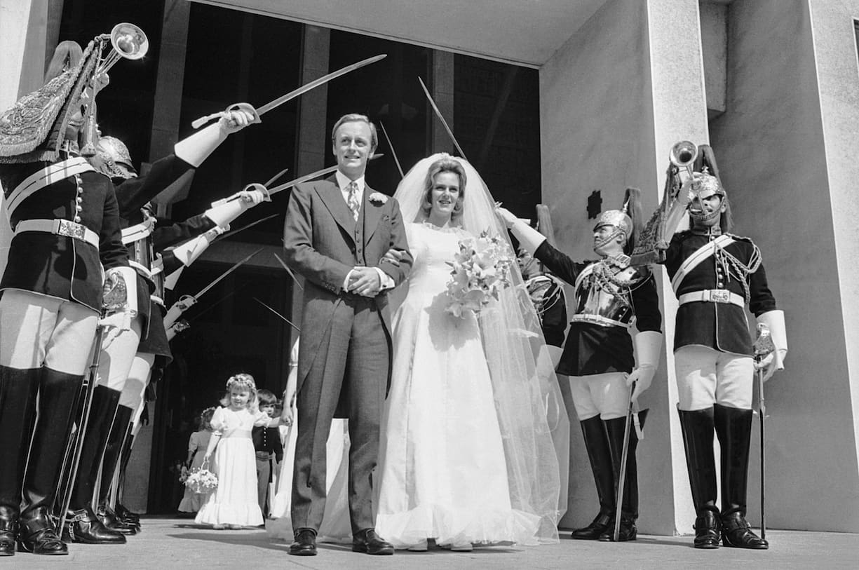 Camilla Shand et le major Andrew Parker-Bowles traversent la garde d'honneur après leur mariage à la Guards Chapel, Wellington Barracks, le 4 juillet 1973.