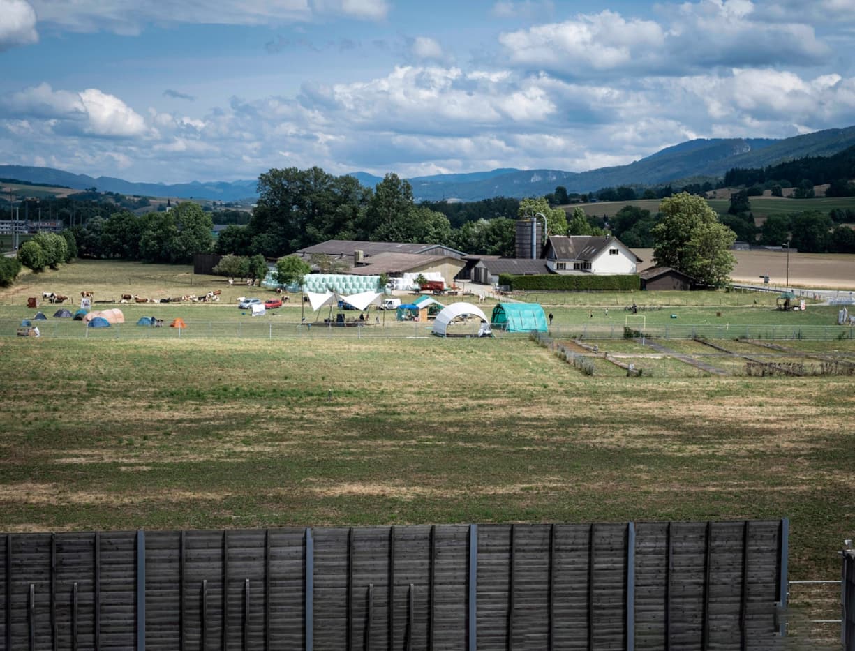 Fracking: c'est sur ce terrain, désormais clôturé et surveillé par un agent de sécurité, que Geo-Energie Suisse prévoit de forer. Juste à côté, les tentes des opposants venus occuper le champ.