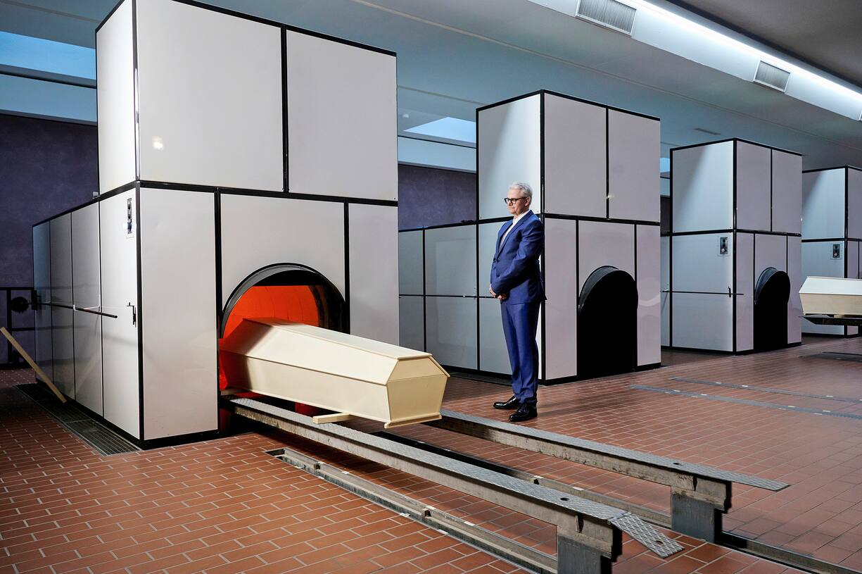 Dans la salle des fours, Andreas Bichler surveille l’entrée d’un cercueil vide. Pour les mises en scène, il troque ses vêtements de travail contre un costume.