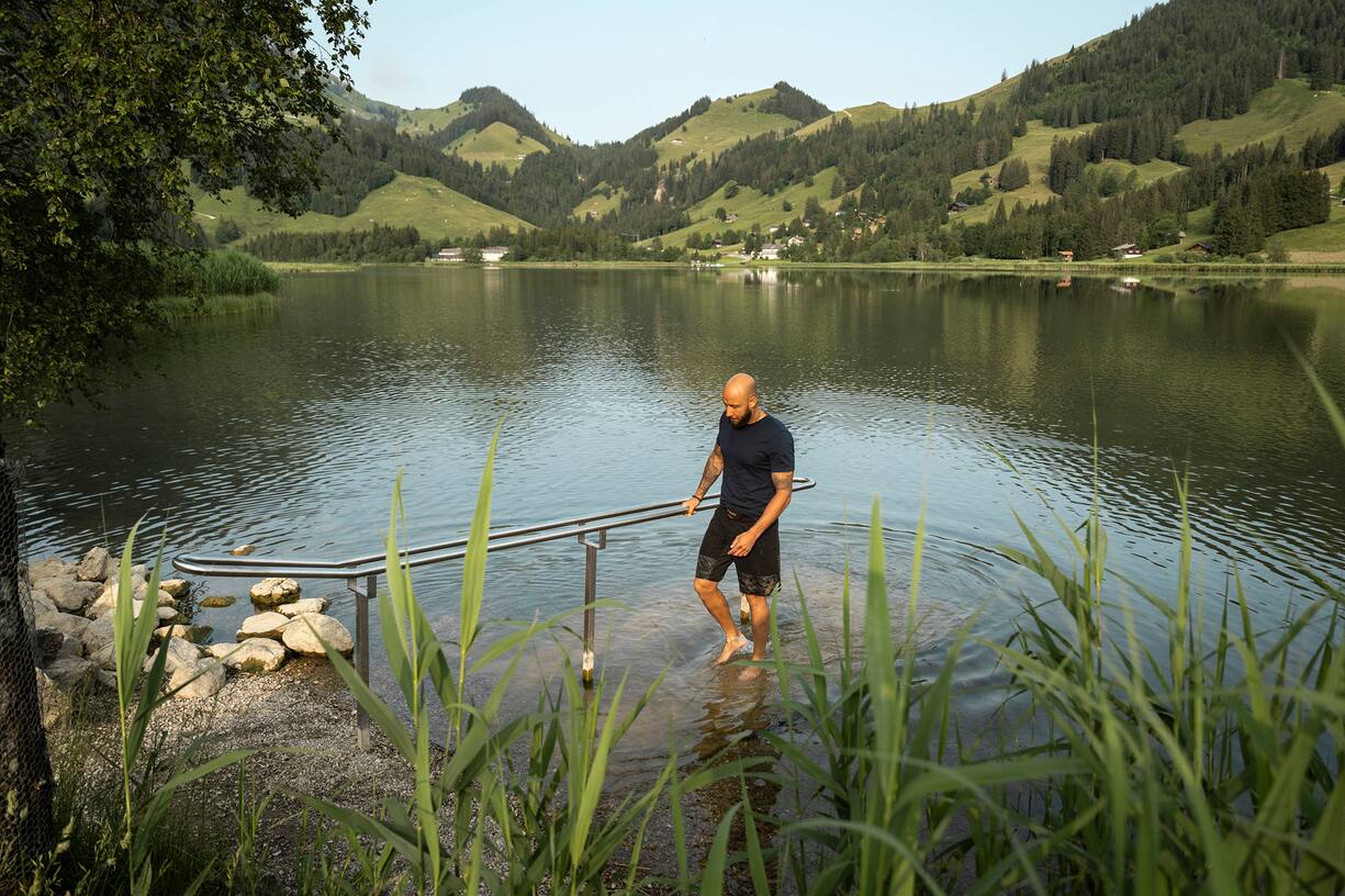 Mann ist am Kneippen (Lâ°uft Wadentief im See) am Schwarzsee