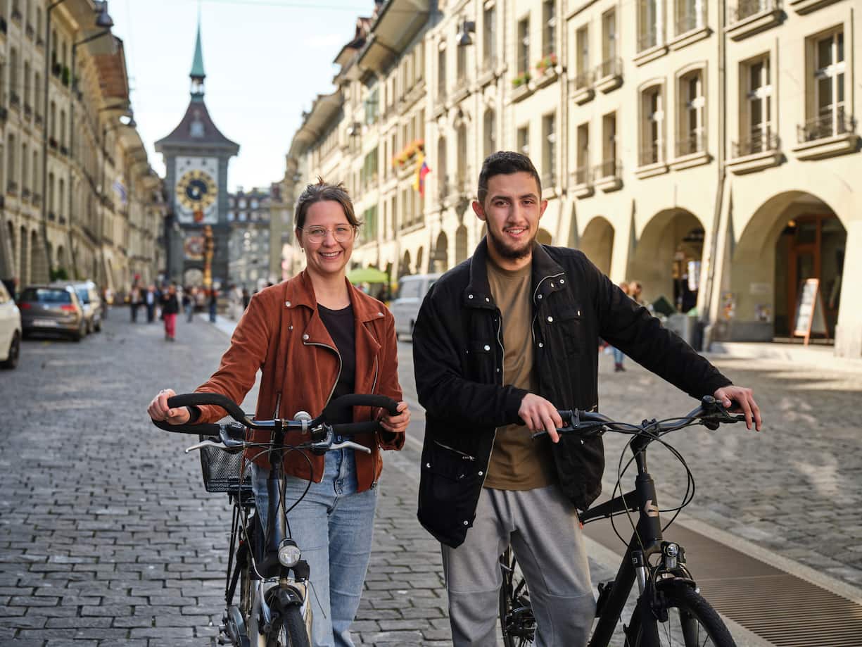 Emirhan Türkoglu et Janine Eberle avec leurs vélos dans la vieille ville de Berne.