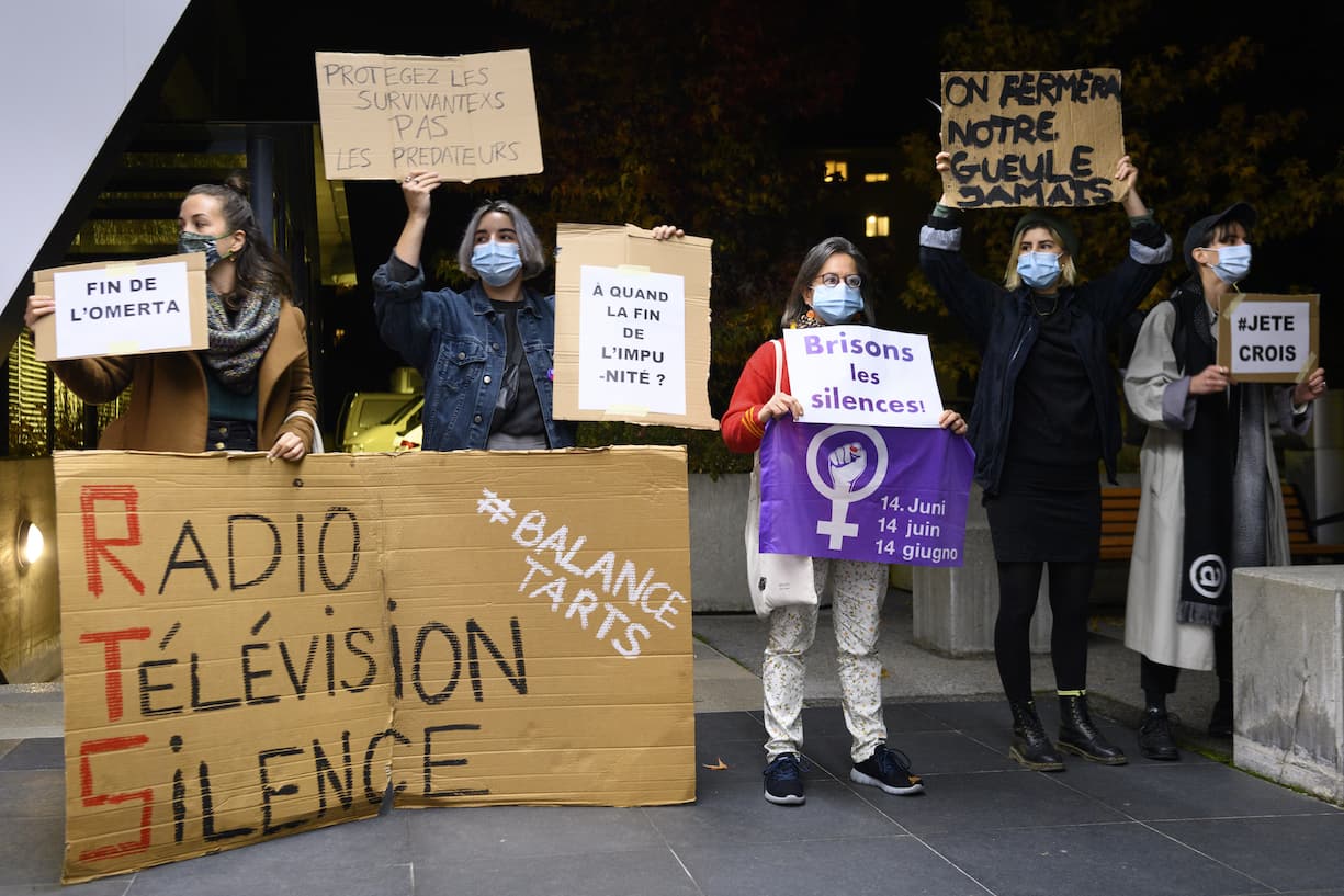 Des femmes brandissent une pancarte lors d'une action de "solidarite feministe" du mouvement "Greve feministe Vaud" suite aux accusations d'harcelement sexuel au sein de la RTS dont  par son ancien presentateur vedette Darius Rochebin ce lundi 2 novembre 2020 devant le siege de la Radio Television Suisse, RTS. (KEYSTONE/Laurent Gillieron)