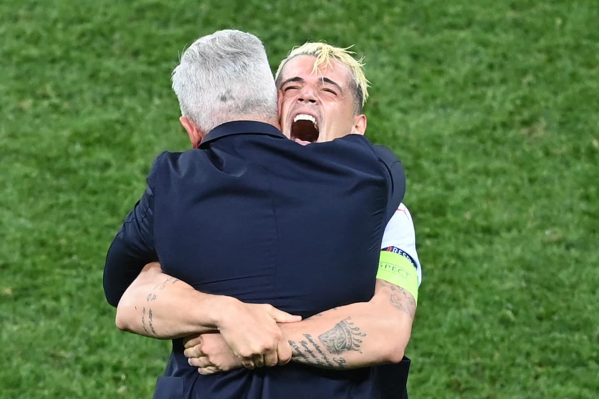 TOPSHOT - Switzerland's midfielder Granit Xhaka embraces Switzerland's Bosnian-Swiss coach Vladimir Petkovic as they celebrate after winning the UEFA EURO 2020 round of 16 football match between France and Switzerland at the National Arena in Bucharest on June 28, 2021. (Photo by Daniel MIHAILESCU / POOL / AFP)