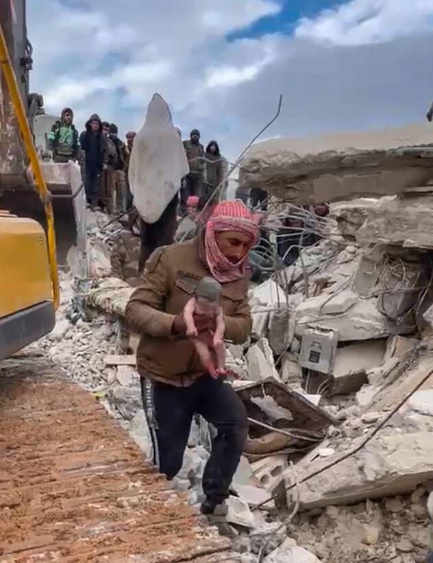 Un sauveteur porte une petite fille après l'avoir extraite des décombres causés par le tremblement de terre qui a frappé la Syrie et la Turquie dans la ville de Jinderis, en Syrie, mardi 7 février 2023. Des habitants de cette ville du nord-ouest de la Syrie ont découvert le bébé en pleurs dont la mère a accouché alors qu'elle était enterrée sous les décombres d'un immeuble de cinq étages rasé par le séisme dévastateur de cette semaine, selon des proches et un médecin.
