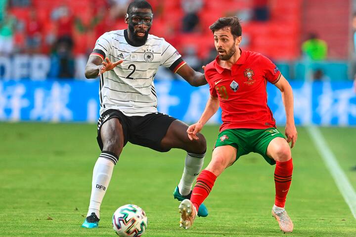 Germany's defender Antonio Ruediger (L) challenges Portugal's midfielder Bernardo Silva during the UEFA EURO 2020 Group F football match between Portugal and Germany at Allianz Arena in Munich, Germany, on June 19, 2021. (Photo by CHRISTOF STACHE / POOL / AFP)