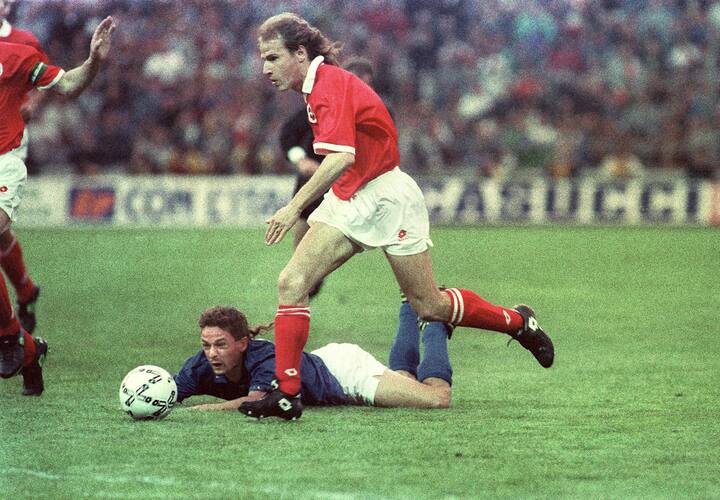 Marc Hottiger zieht im WM-Qualifikationsspiel Schweiz-Italien am 1. Mai 1993 im Wankdorf-Stadion in Bern am gestuerzten italienischen Spieler Roberto Baggio vorbei. Hottiger erzielt fuer die Schweiz in der 55. Minute das Tor zum 1:0 Sieg. (KEYSTONE/Str)
