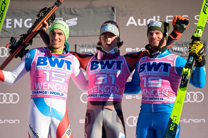 Switzerland's Daniel Yule (L), 2nd place, Norway's Lucas Braathen (C), 1st place, and Italy's Giuliano Razzoli (R), 3rd place, celebrate on the podium after the men's FIS Ski World Cup Slalom in Wengen, Switzerland, on January 16, 2022. (Photo by Fabrice COFFRINI / AFP)