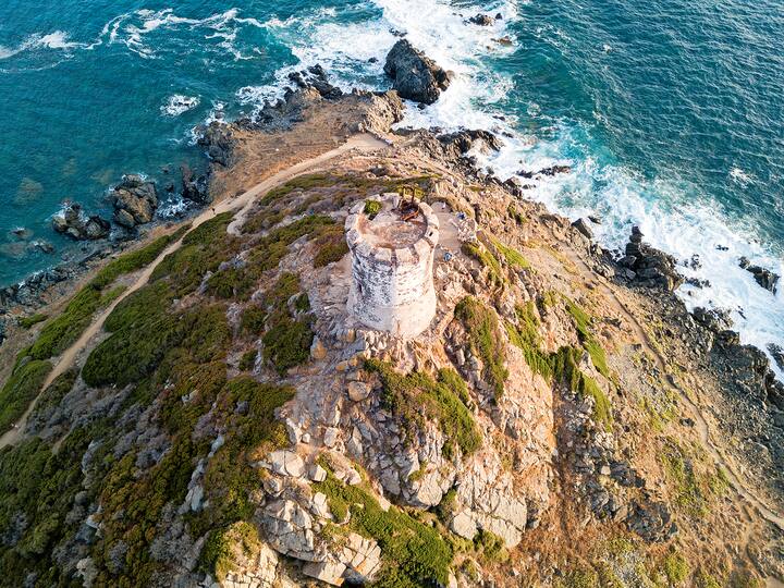 Aerial view of the Parata Tower from the sea, Genoese tower built in 1608, Corsica. France. Sunset over the sea in the Gulf of Ajaccio near the bloody islands