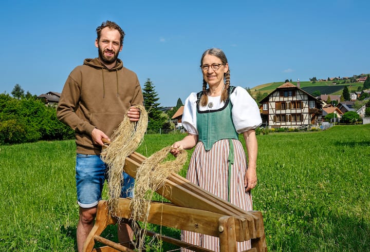 Le gardien de hockey sur glace Sandro Aeschlimann et Hanna Stalder vont travailler le lin dans la prairie où se déroulera la Brächete de Zäziwil, cette année encore.