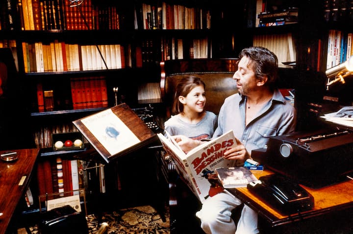 Paris, juin 1983: Serge Gainsbourg chez lui, rue de Verneuil, lisant une anthologie de bandes dessinées Walt Disney avec sa fille Charlotte.