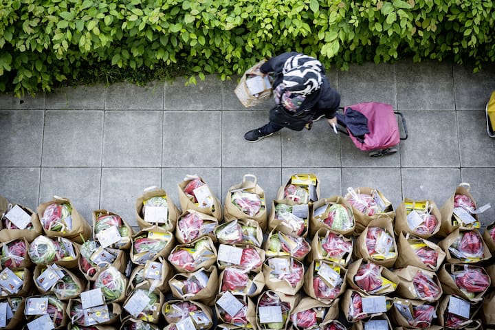 Les bénéficiaires passent tôt le matin afin d’être sûrs d’avoir un ticket pour recevoir leurs sacs contenant quelques produits frais et secs.