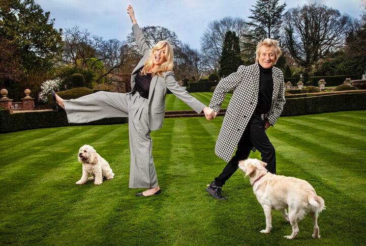 Le musicien écossais Rod Stewart et sa compagne Penny Lancaster dans le jardin de leur manoir avec leurs chiens Bubbles et Lily