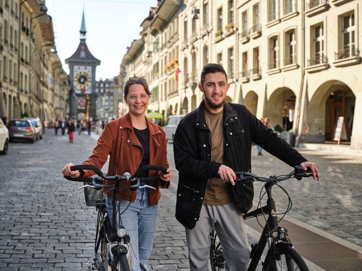 Emirhan Türkoglu et Janine Eberle avec leurs vélos dans la vieille ville de Berne.