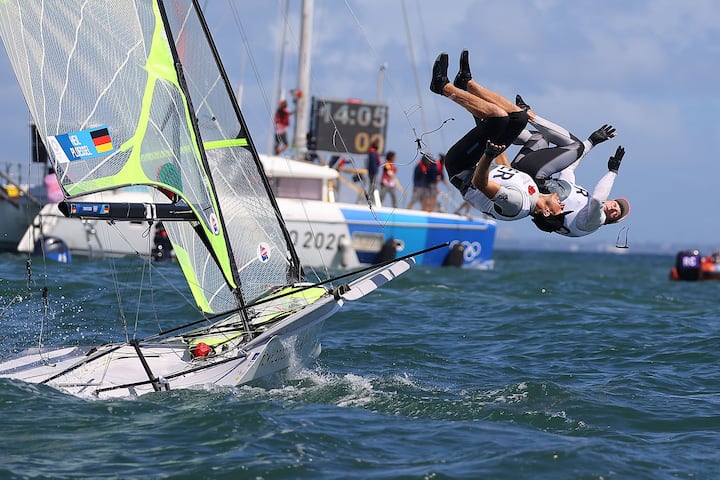 Tokyo 2020 Olympics - Sailing - Men's 49er - Medal Race - Enoshima Yacht Harbour - Tokyo, Japan - August 3, 2021. Erik Heil of Germany and Thomas Ploessel of Germany jump into the water as they celebrate winning bronze after the race. REUTERS/Carlos Barria    SEARCH "OLYMPICS DAY 12" FOR TOKYO 2020 OLYMPICS EDITOR'S CHOICE, SEARCH "REUTERS OLYMPICS TOPIX" FOR ALL EDITOR'S CHOICE PICTURES.TPX IMAGES OF THE DAY.