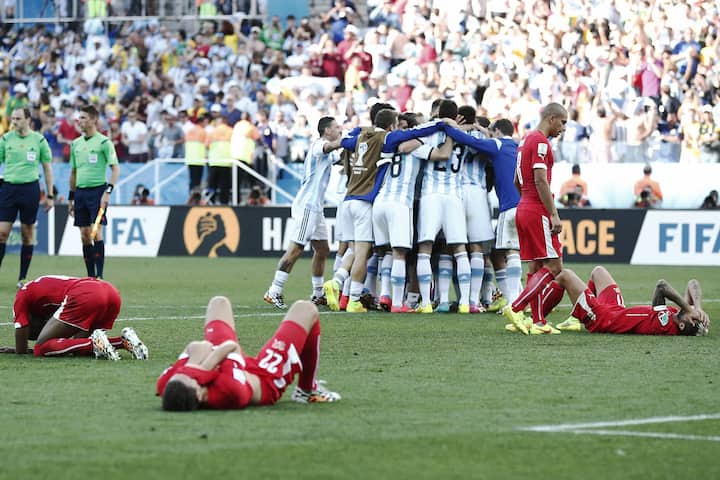 ARCHIVBILD ZUR ENDSTATION ACHTELFINAL --- Switzerland's players lie on the ground while Argentina's players celebrate after the Round of 16 match between Switzerland and Argentina in the Arena de Sao Paulo in Sao Paulo, Brazil, Tuesday, July 01, 2014. (KEYSTONE/Peter Klaunzer)