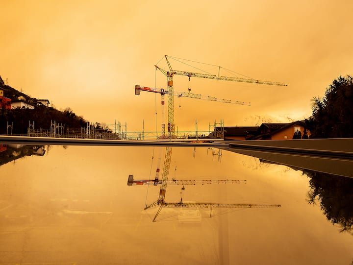 Début d’après-midi à Bramois (Sion, VS), une grue se détache sur le ciel orangé
