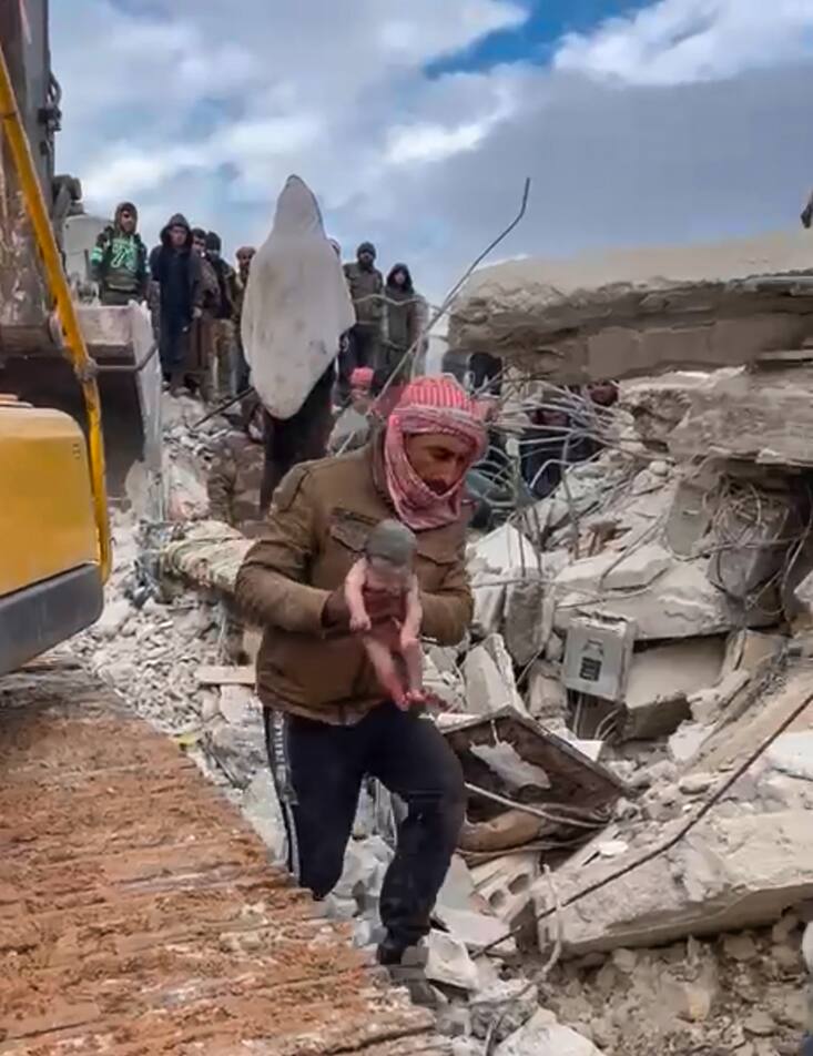 Un sauveteur porte une petite fille après l'avoir extraite des décombres causés par le tremblement de terre qui a frappé la Syrie et la Turquie dans la ville de Jinderis, en Syrie, mardi 7 février 2023. Des habitants de cette ville du nord-ouest de la Syrie ont découvert le bébé en pleurs dont la mère a accouché alors qu'elle était enterrée sous les décombres d'un immeuble de cinq étages rasé par le séisme dévastateur de cette semaine, selon des proches et un médecin.